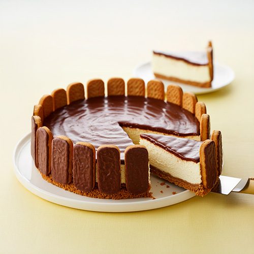 Torta holandesa com cobertura de chocolate e biscoitos nas laterais, servida em fatia sobre prato branco